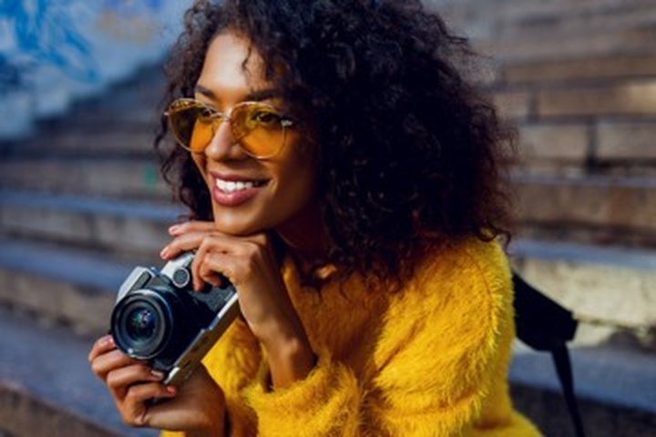 A confident young creative with a camera — building independence and upward mobility